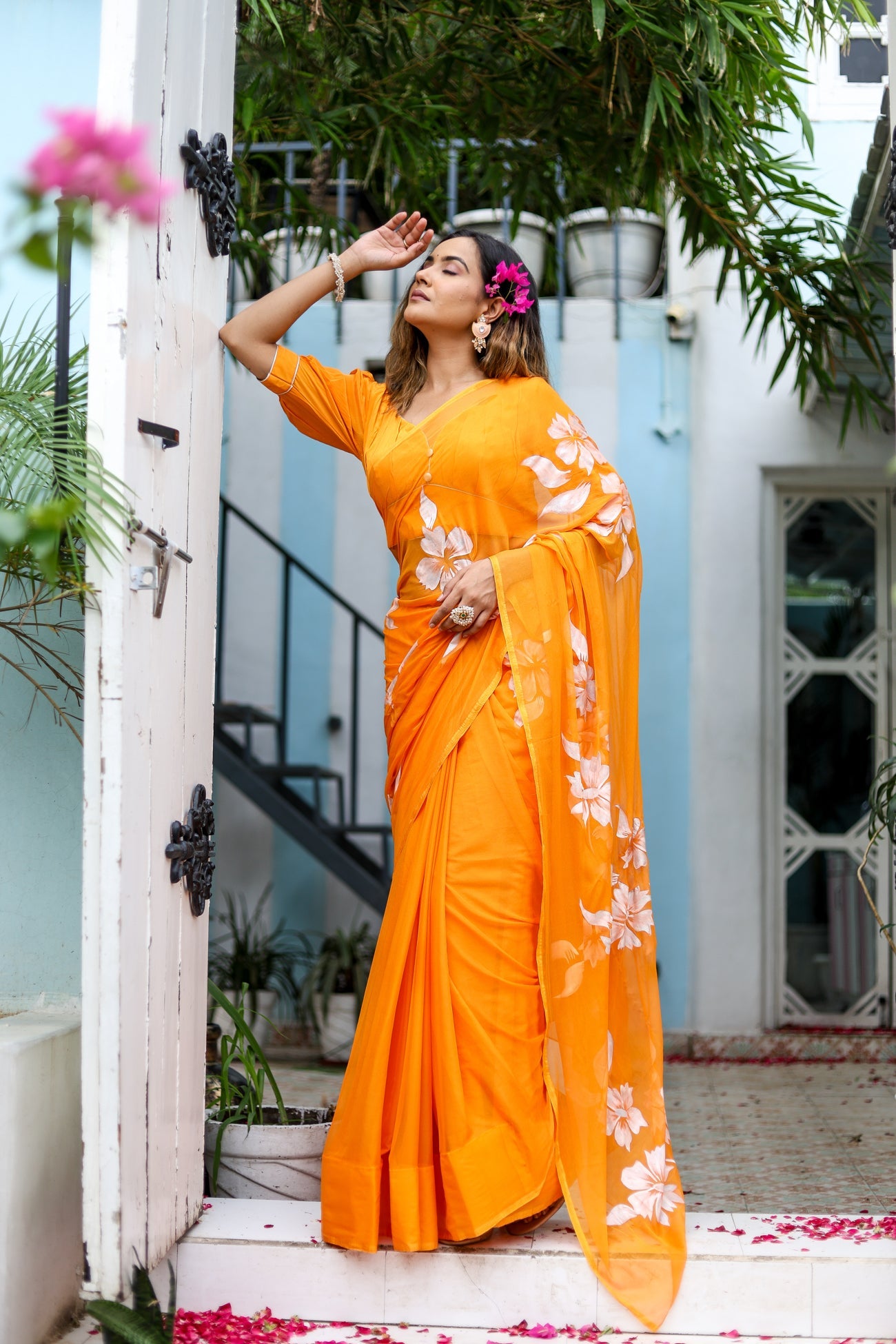 Stylera handpainted chiffon saree in vibrant orange with floral designs for elegant occasions