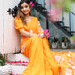 Elegant woman wearing a handpainted chiffon saree in vibrant orange with floral designs, seated in a garden