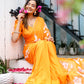 Elegant model wearing a handpainted chiffon saree in vibrant orange with floral designs for festive occasions