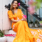 Bright orange handpainted chiffon saree with floral designs, styled elegantly for a special occasion