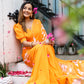 Bright orange handpainted chiffon saree with floral designs, worn elegantly by a smiling woman