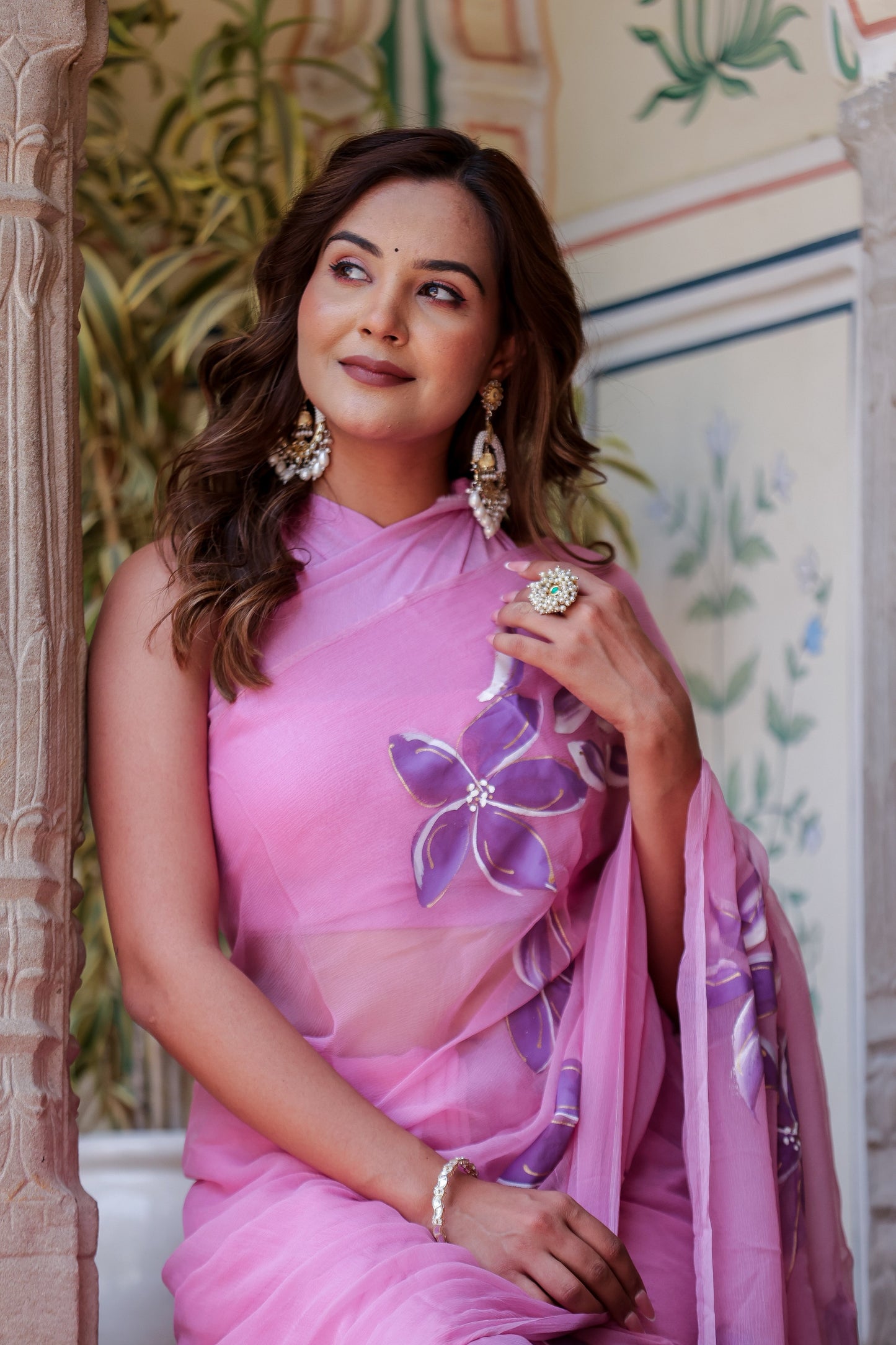 Elegant model wearing a handpainted lavender chiffon saree with floral designs and accessories