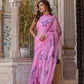 Elegant model wearing a handpainted lavender chiffon saree with intricate floral designs in a picturesque setting