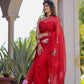 Elegant woman wearing a handpainted red organza saree with floral designs, styled with matching accessories
