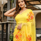 Elegant model wearing a handpainted yellow chiffon saree with floral designs for festive occasions