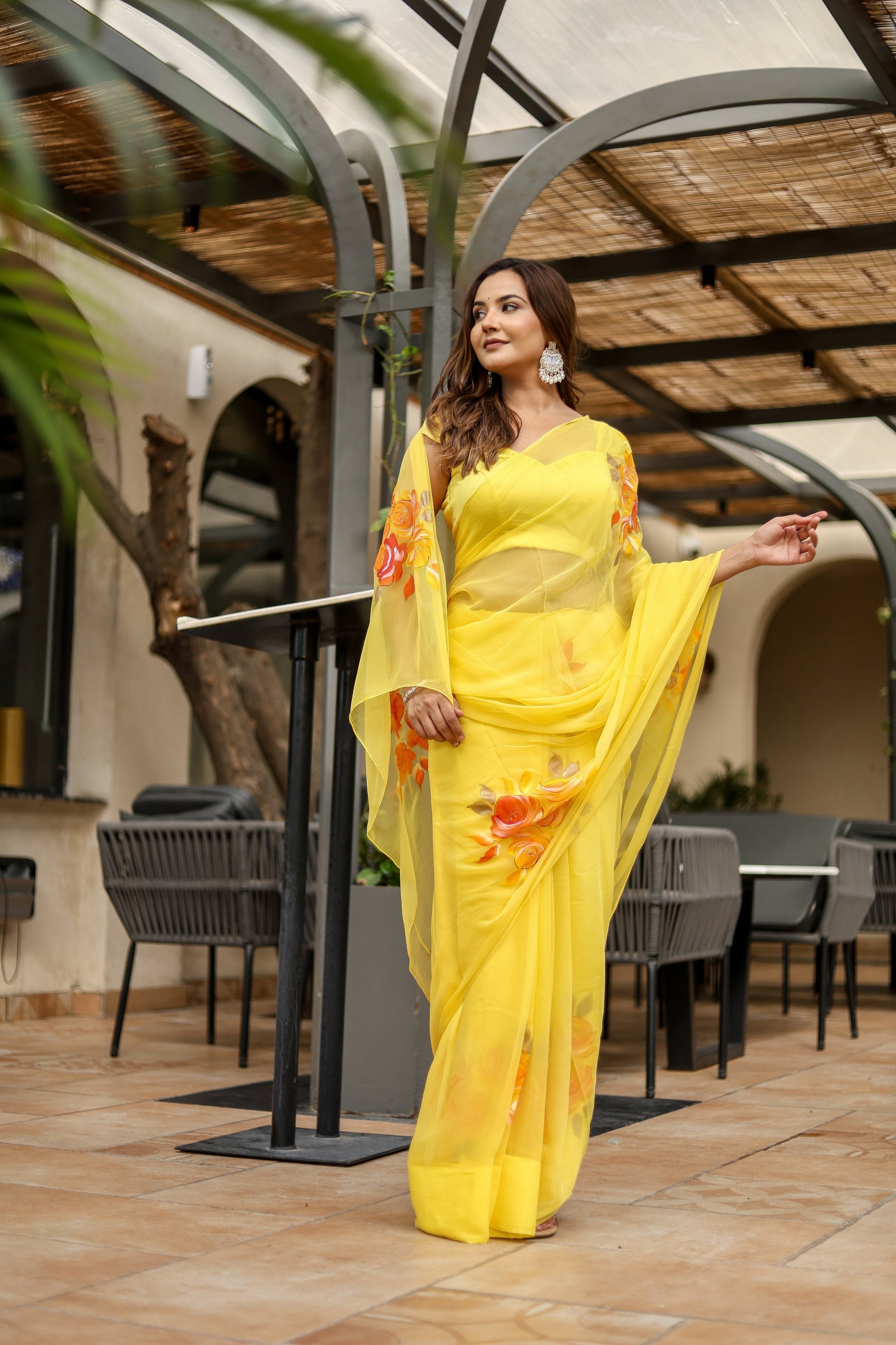 Elegant handpainted yellow chiffon saree with floral designs, perfect for festive occasions.