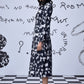 Model side view wearing Stylera heart print black dress knee length long sleeve for casual chic