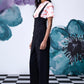 Stylera model wearing black high waist lace up overalls with wide legs and white sneakers
