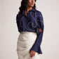 Stylera ivory white draped skirt paired with navy blue long sleeve blouse with white piping