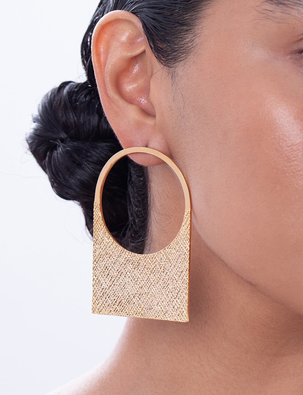 Stylera gold textured geometric drop earrings on model close up fashion statement earrings