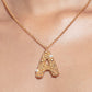 Stylera gold letter A pendant necklace with textured beaded gold and small pearl accents on delicate chain