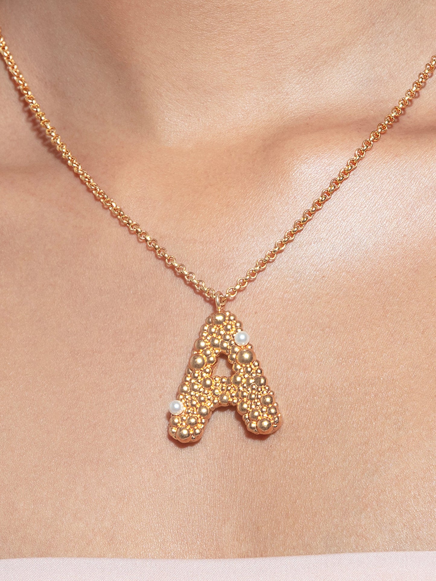 Stylera gold letter A pendant necklace with textured beaded gold and small pearl accents on delicate chain