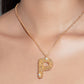 Stylera gold letter P pendant necklace on model with textured pave stones and delicate chain