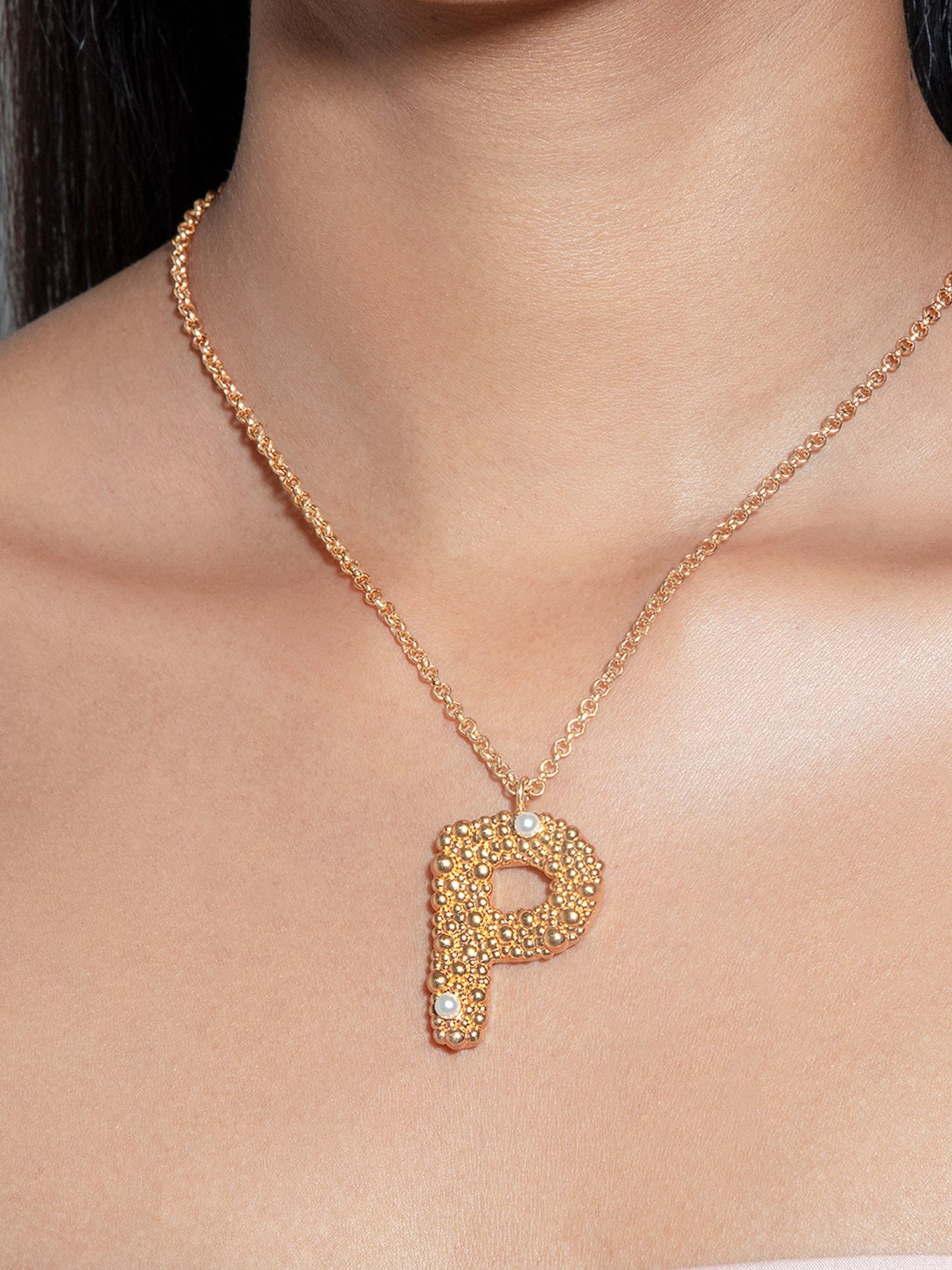 Stylera gold letter P pendant necklace on model with textured pave stones and delicate chain