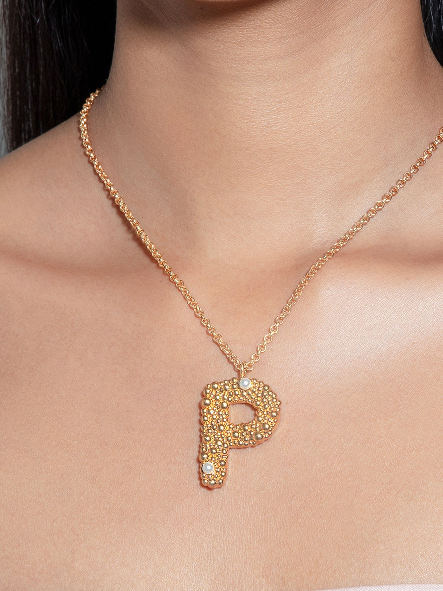 Stylera gold letter P pendant necklace on model with textured pave stones and delicate chain