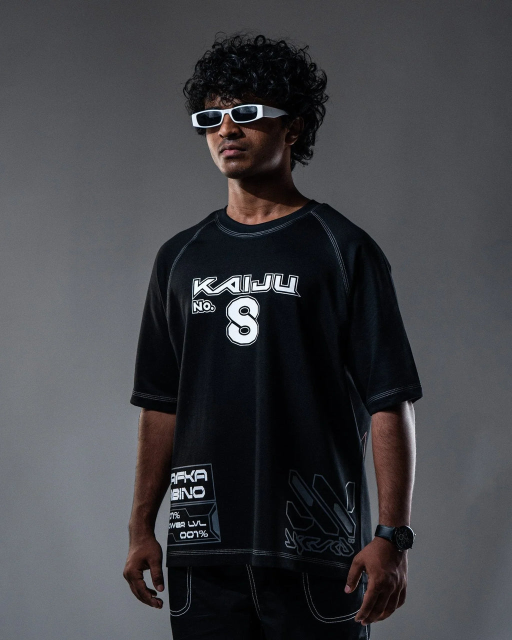 Person wearing a black t-shirt with 'Kaiju' branding against a gray background
