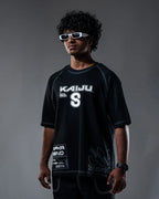 Person wearing a black t-shirt with 'Kaiju' branding against a gray background
