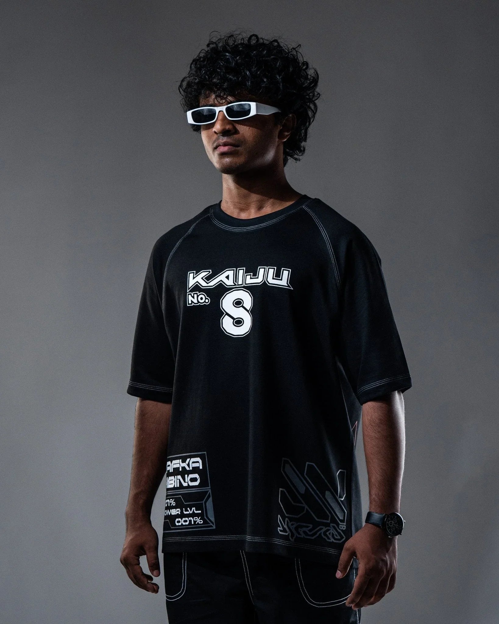 Person wearing a black t-shirt with 'Kaiju' branding against a gray background
