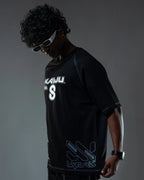 Person wearing a black t-shirt with logos on a dark background