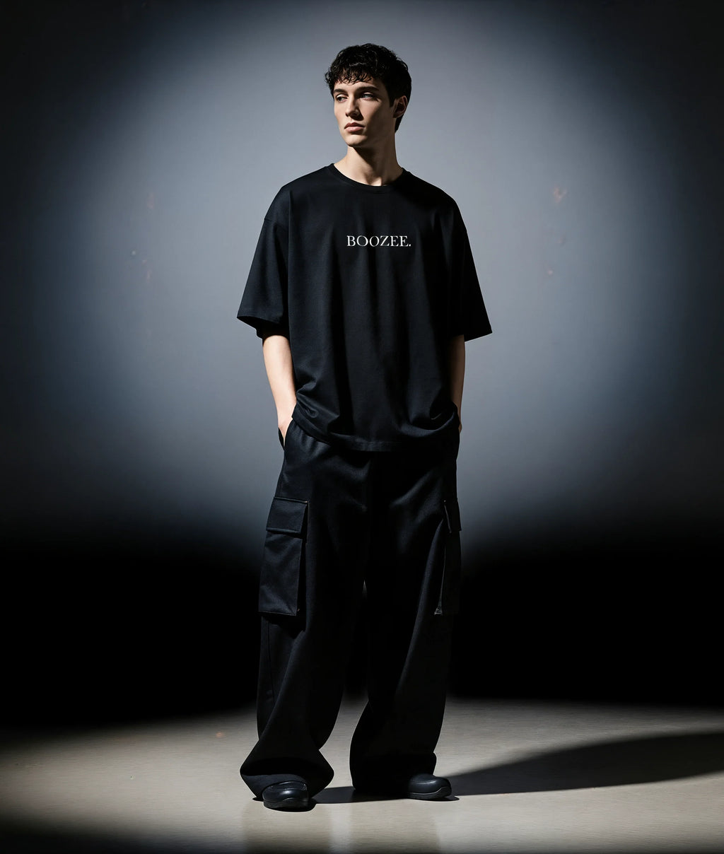 Person wearing a black 'BOOZEE' t-shirt and pants against a dark background