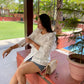 Ladies ruffle sleeve white shirt styled with denim shorts for a chic summer look