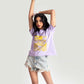 Woman wearing a lavender graphic t-shirt for women paired with distressed denim shorts