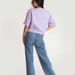 Stylera lavender oversized crop top worn by model paired with blue jeans and white sneakers