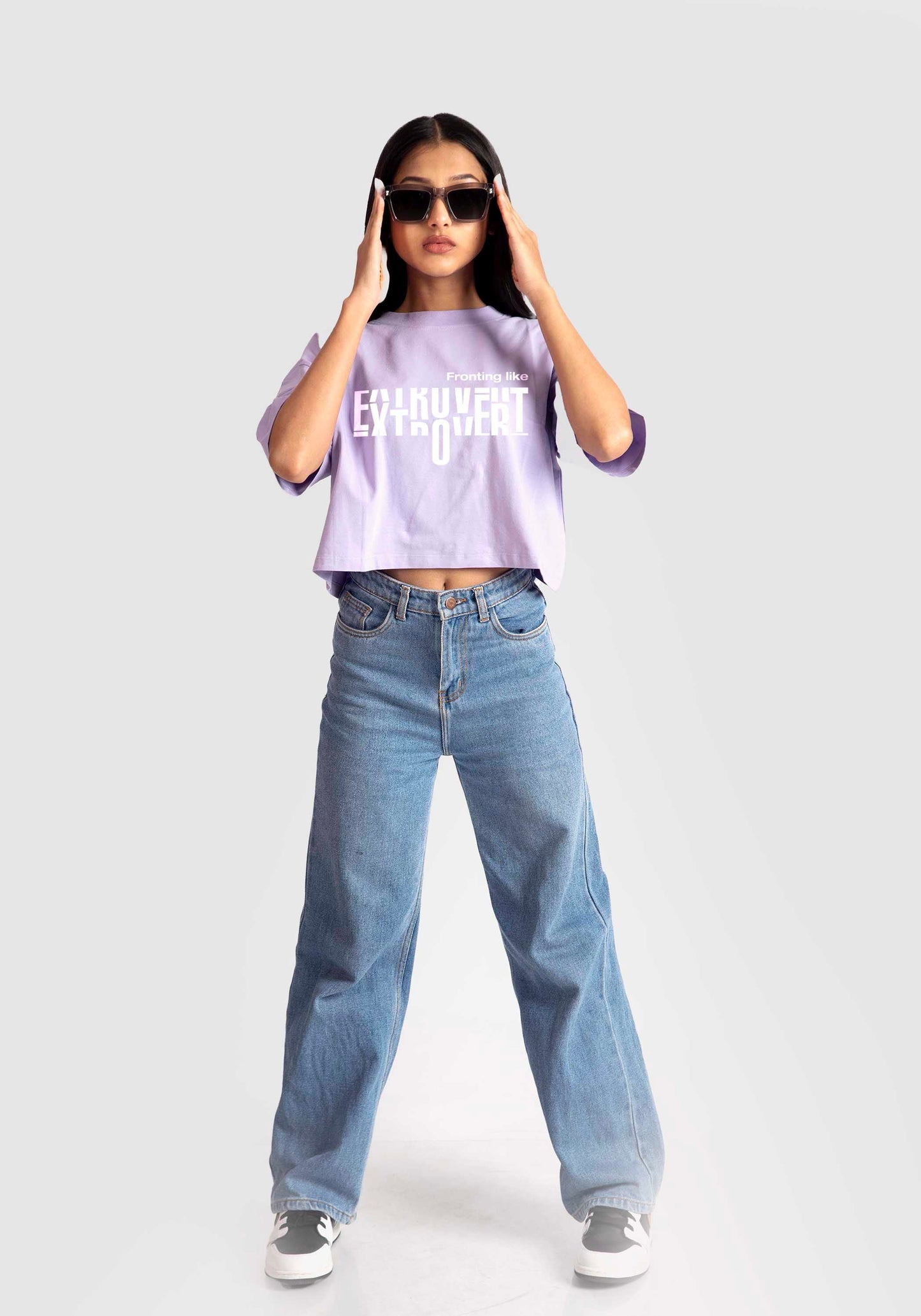 Stylera lavender oversized crop top worn by model with casual blue jeans and sunglasses
