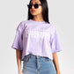Stylera lavender oversized crop top with white graphic print worn with blue jeans