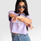 Woman wearing Stylera lavender oversized crop top paired with high-waisted blue jeans and sunglasses