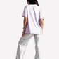 Back view of a woman wearing Stylera lavender oversized t-shirt with light wash jeans and sneakers