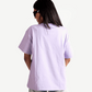 Back view of woman wearing Stylera lavender oversized t-shirt with light denim jeans