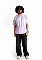 Man wearing Stylera lavender oversized t-shirt paired with black pants and sunglasses