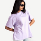 Woman wearing lavender oversized t-shirt from Stylera styled with ripped light jeans and black sunglasses