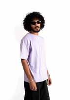Man wearing Stylera lavender oversized t-shirt with black shorts and sunglasses