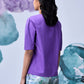 Stylera lavender regular fit top shown from back on model with elbow sleeves and printed pants