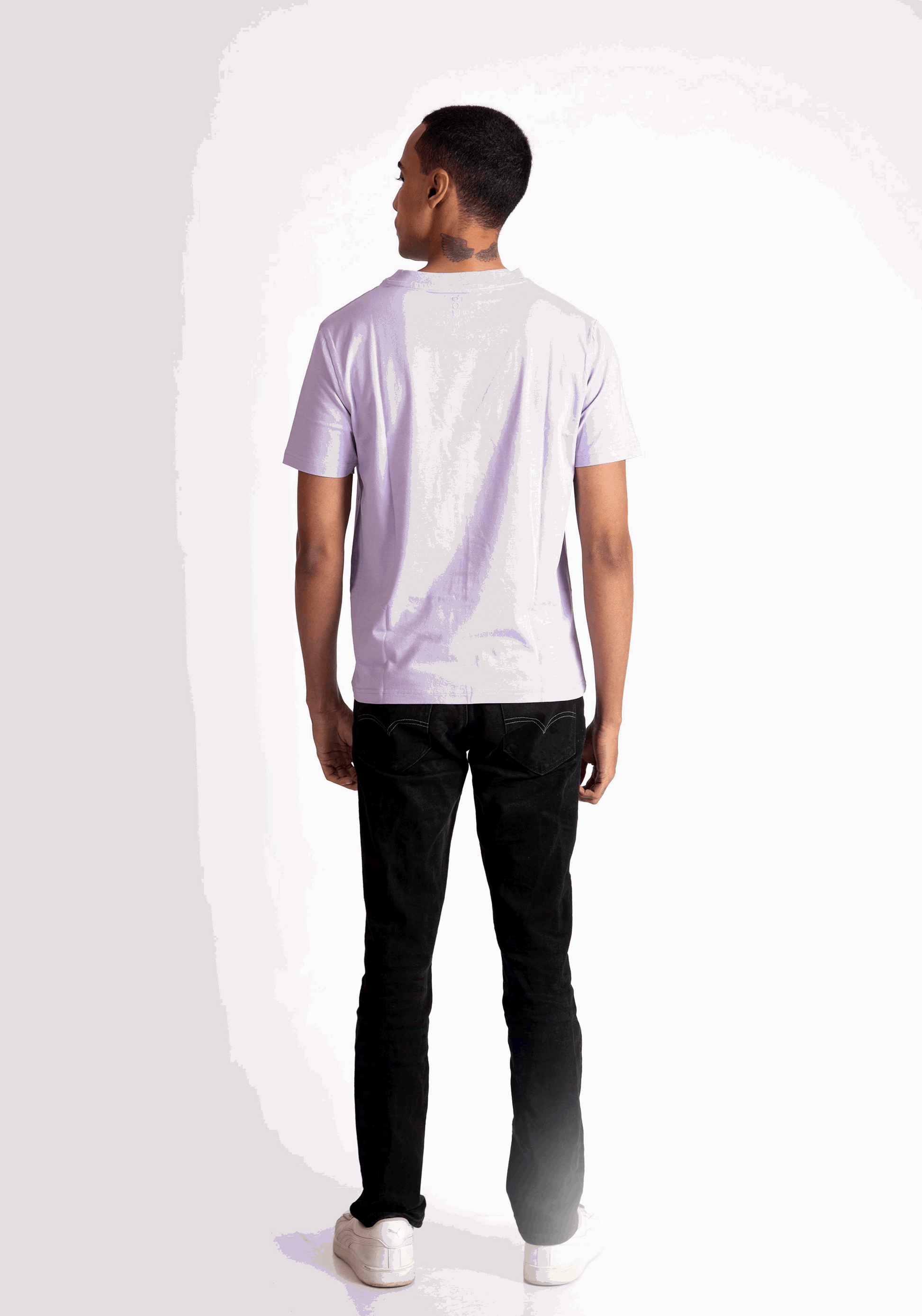 Back view of a man wearing a lavender t-shirt for men paired with black pants and white sneakers