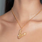 Stylera letter V pendant necklace in gold with crystal and pearl accents on model neckline