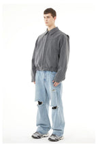Back view of light blue ripped jeans men styling with a casual streetwear aesthetic.