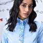 Model wearing light blue sequin dress by Stylera with collared long sleeves and floral sequin placket