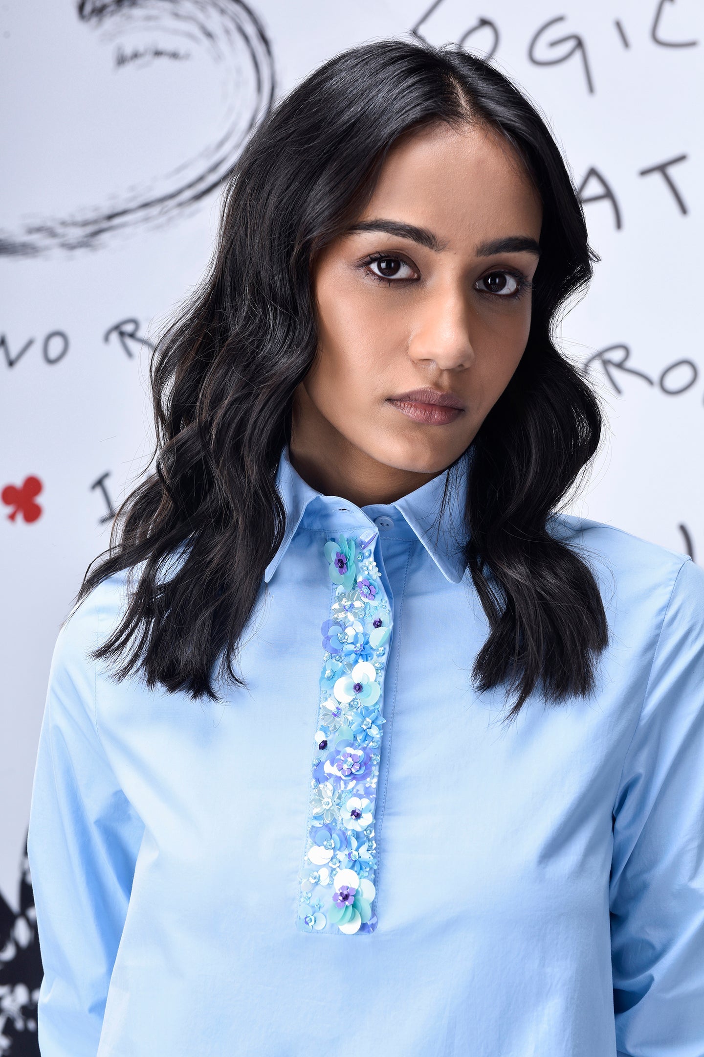 Model wearing light blue sequin dress by Stylera with collared long sleeves and floral sequin placket
