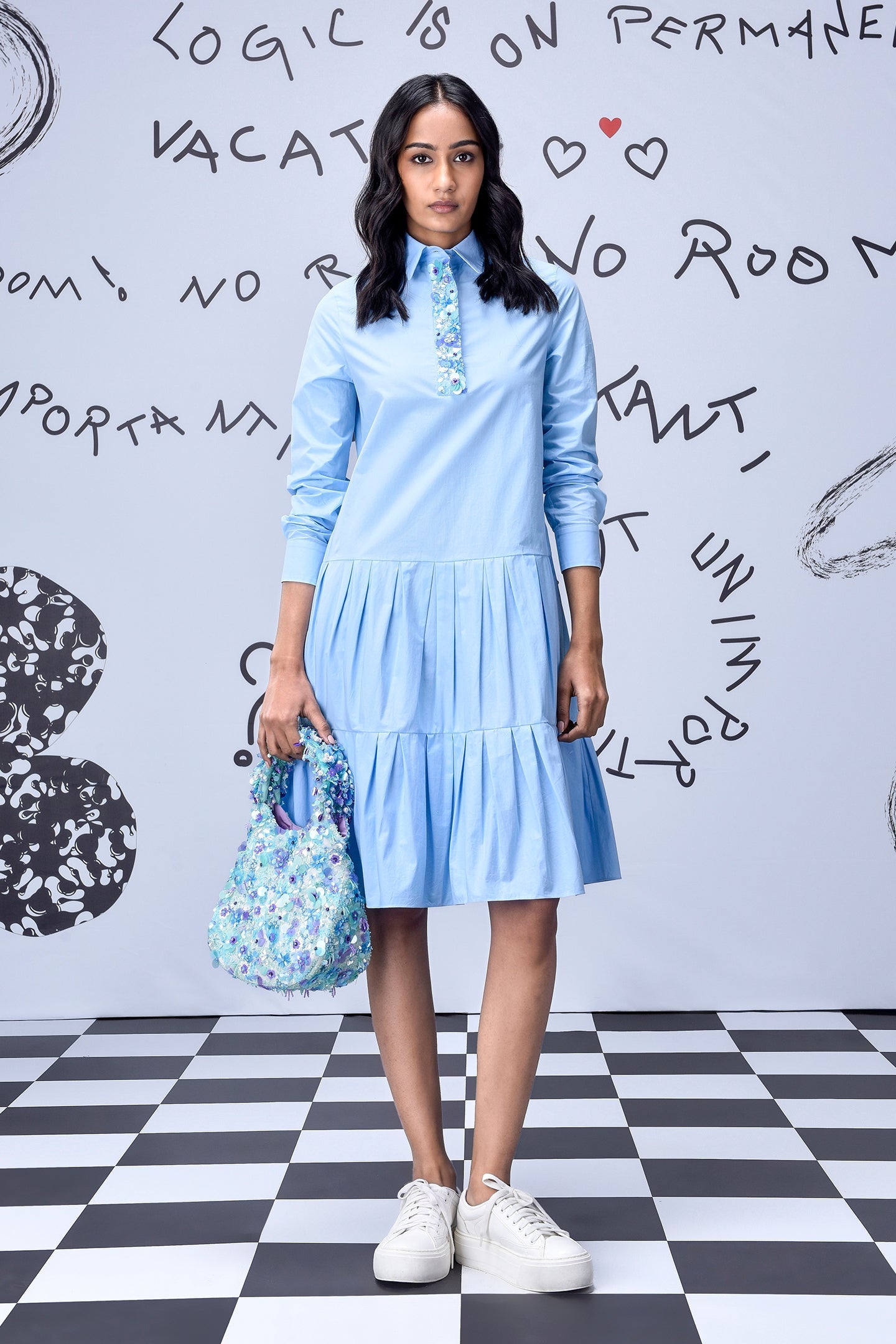 Model wearing light blue tiered shirt dress with floral tote bag and white sneakers for light blue sequin dress listing