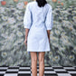 Back view of model wearing light blue wrap dress by Stylera with elbow sleeves