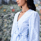 Stylera model wearing light blue wrap dress with puff sleeves tie waist and V neckline