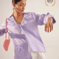 Stylera light purple fashion top with ruffle details and front pockets worn by woman