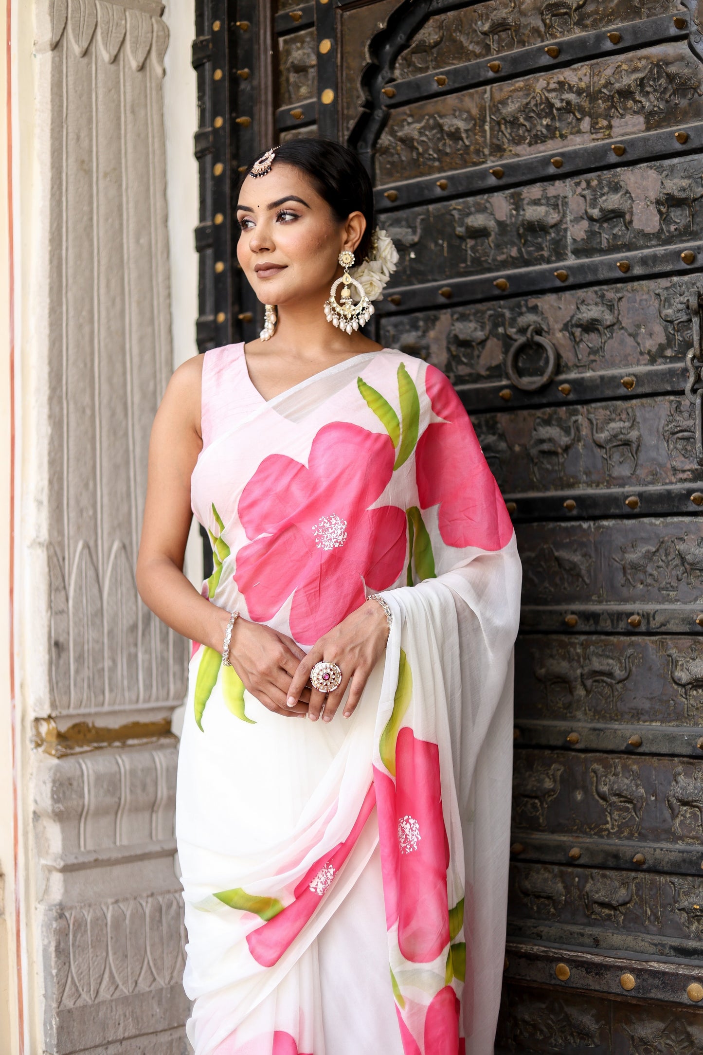Elegant woman in a lightweight party wear chiffon saree with vibrant pink floral design