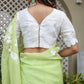 Back view of a woman in a lightweight party wear saree paired with a white blouse and decorative earrings
