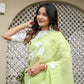 Lightweight party wear saree in green with floral designs, styled elegantly for a festive look