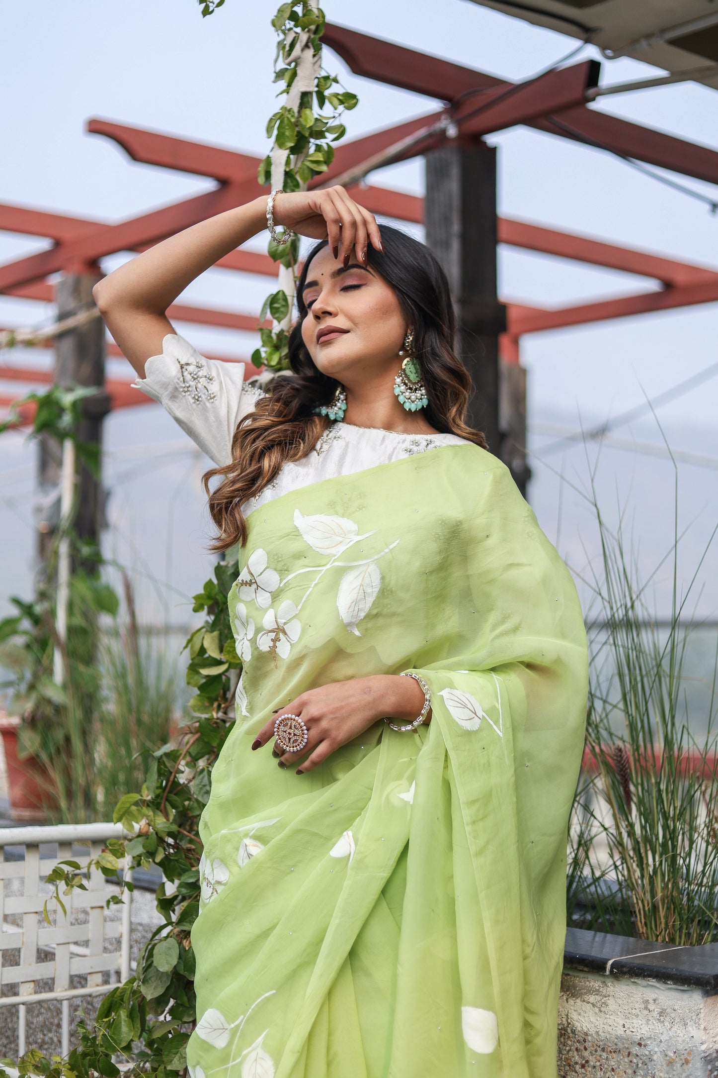 Lightweight party wear saree in soft green, adorned with floral patterns, perfect for festive occasions