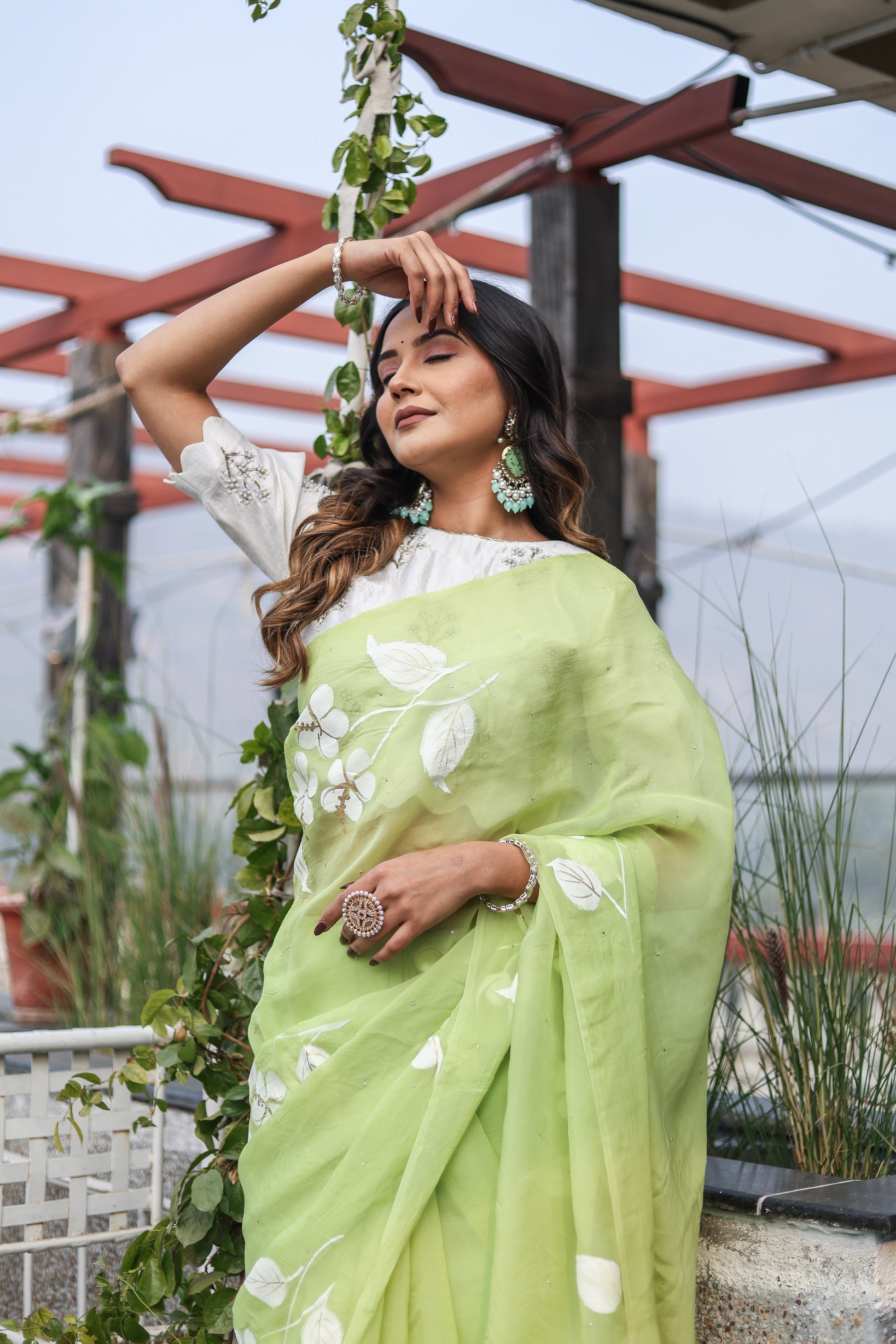 Lightweight party wear saree in soft green, adorned with floral patterns, perfect for festive occasions